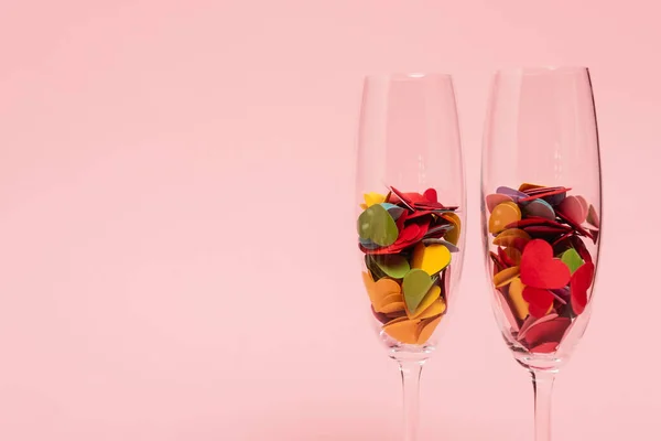 Bunte Herzen in Champagnergläsern isoliert auf rosa — Stockfoto