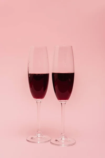 Vino tinto en copas aisladas en rosa - foto de stock