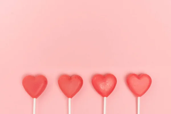 Top view of heart shaped lollipops on pink background — Stock Photo