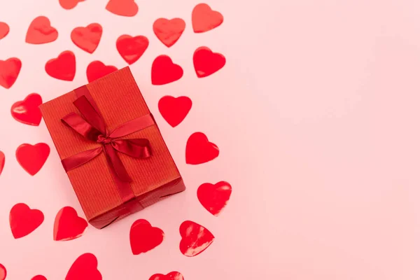 Top view of red hearts and gift box on pink background — Stock Photo