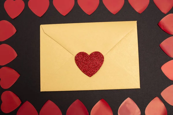 Vista superior de corações e envelope dos namorados isolado em preto — Fotografia de Stock