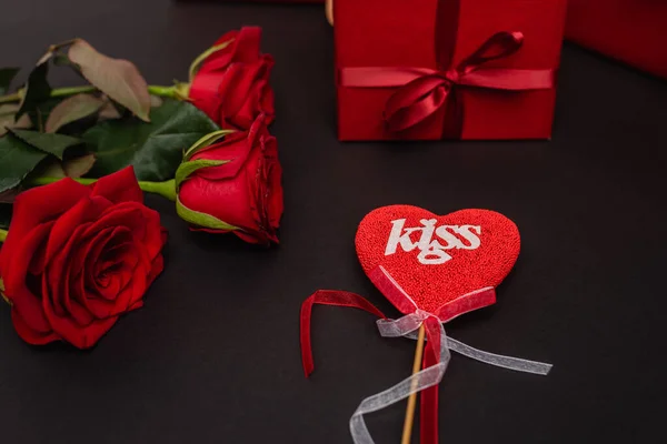 Roses, cadeaux de valentines et coeur sur bâton isolé sur noir — Photo de stock