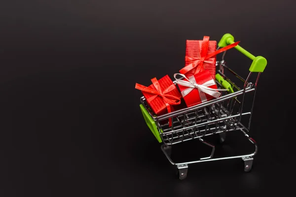 Shopping cart with valentines gifts isolated on black — Stock Photo