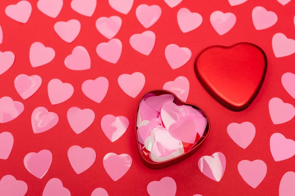 Top view of pink hearts and box on red background — Stock Photo