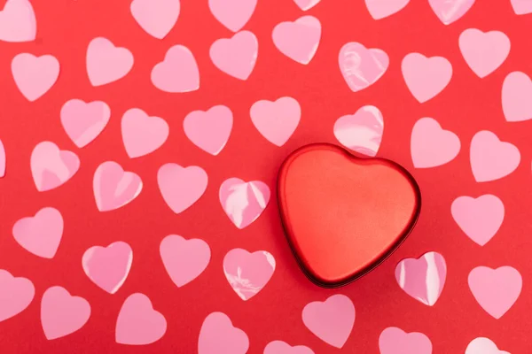 Vista dall'alto di cuori rosa e scatola su sfondo rosso — Stock Photo