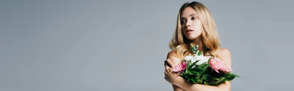 Affascinante giovane donna con spalle nude in posa con bouquet isolato su grigio, banner — Foto stock