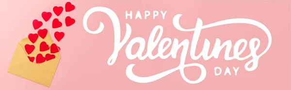 Draufsicht auf rote Papierherzen und Umschlag in der Nähe von glücklichen Valentinstagen Schriftzug auf rosa Hintergrund, Banner — Stockfoto