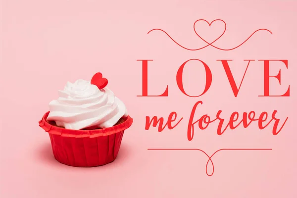 Valentines cupcake with red heart near love me forever lettering on pink background — Stock Photo