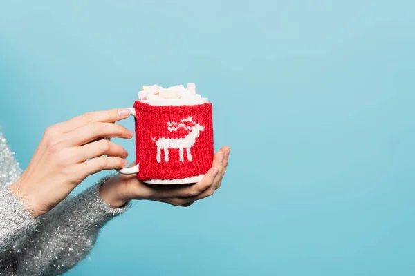 Vista recortada de la mujer sosteniendo la taza con malvaviscos y titular de punto aislado en azul - foto de stock