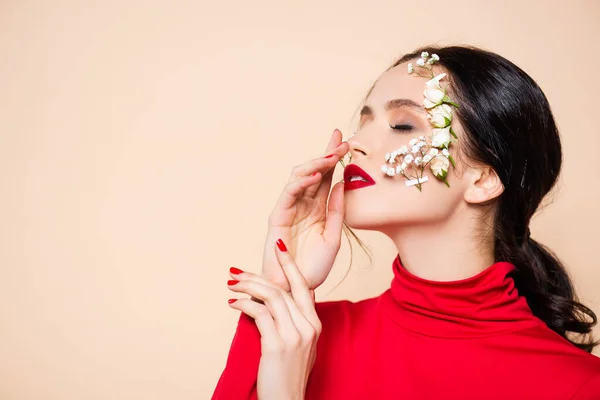 Jovem com lábios vermelhos e flores no rosto com olhos fechados isolados em rosa — Fotografia de Stock