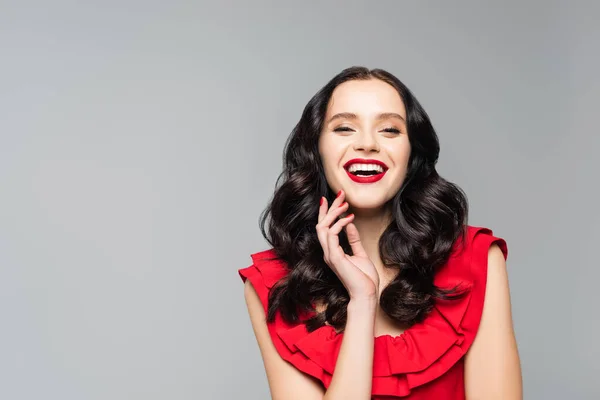 Alegre joven con labios rojos aislados en gris - foto de stock