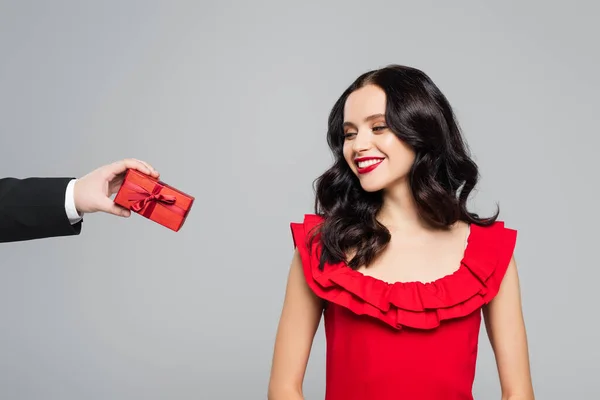 Man holding gift box near cheerful woman with red lips isolated on grey — Stock Photo