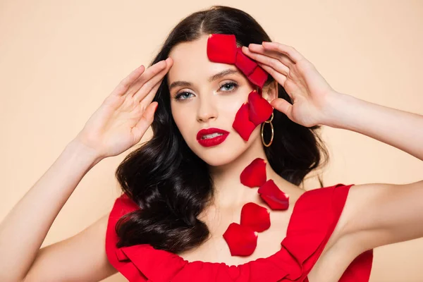 Jeune femme aux pétales de rose sur le visage isolé sur rose — Photo de stock