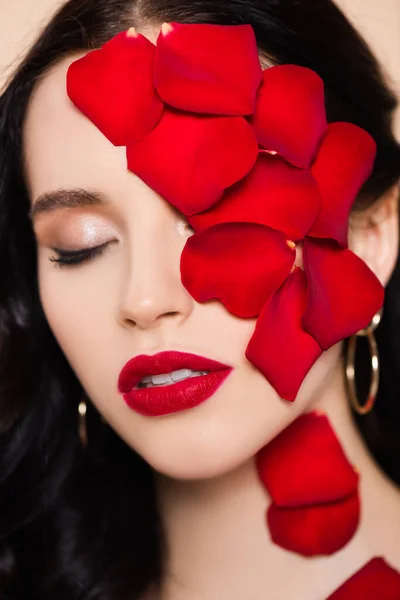 Красива молода жінка з закритими очима і пелюстками троянд на обличчі — стокове фото