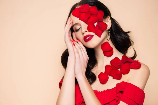 Hübsche junge Frau mit geschlossenen Augen und Rosenblättern im Gesicht isoliert auf rosa — Stockfoto