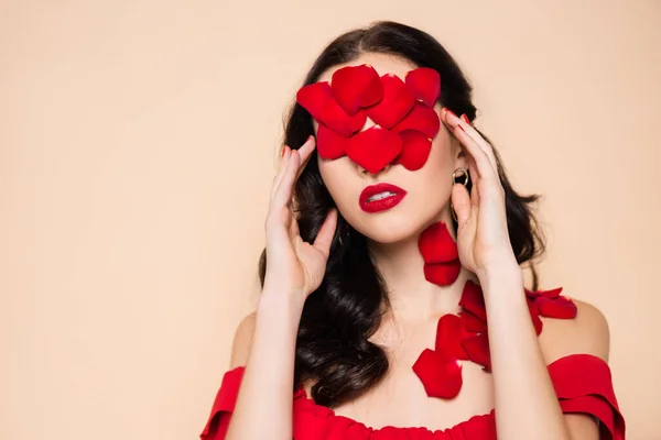 Brunette young woman with rose petals on face isolated on pink — Stock Photo