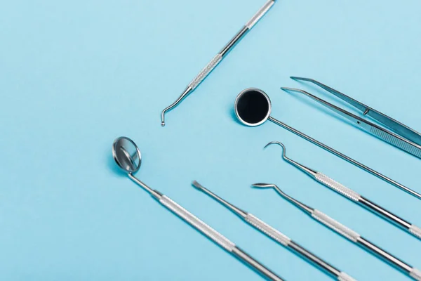 Vista de alto ângulo de ferramentas odontológicas definidas no fundo azul — Fotografia de Stock