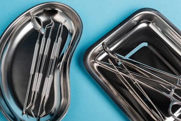 Top view of trays with dental tools on blue background — Stock Photo