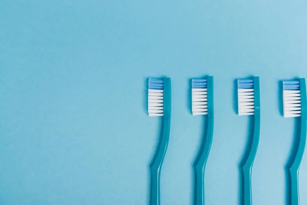 Vista superior de cepillos de dientes de plástico sobre fondo azul — Stock Photo