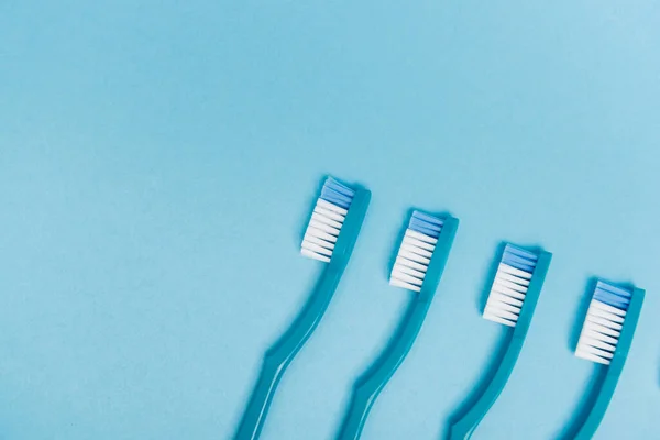 Vista superior de cepillos de dientes sobre fondo azul - foto de stock