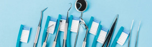 Vista superior de escovas de dentes e ferramentas odontológicas em fundo azul, banner — Fotografia de Stock