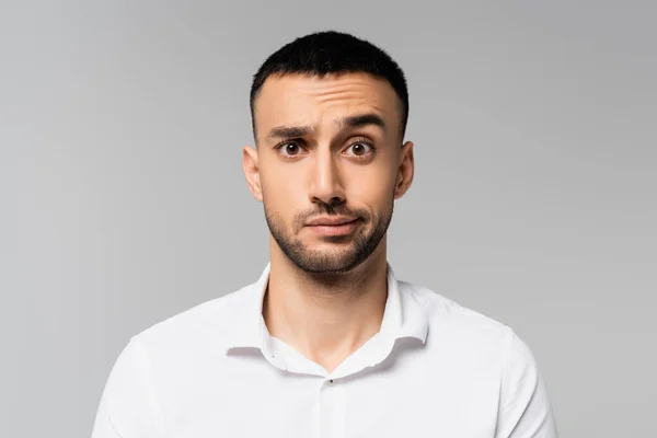 Confused hispanic businessman looking at camera isolated on grey — Stock Photo