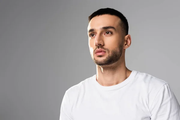 Selbstbewusster, brünetter hispanischer Mann in weißem T-Shirt, der isoliert auf grau blickt — Stockfoto