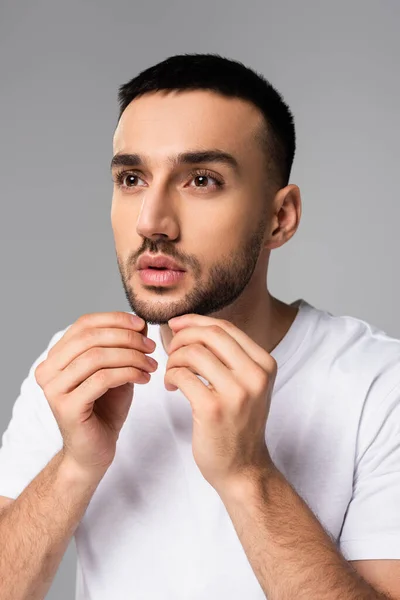 Unshaved hispanic man touching bristle on face isolated on grey — Stock Photo