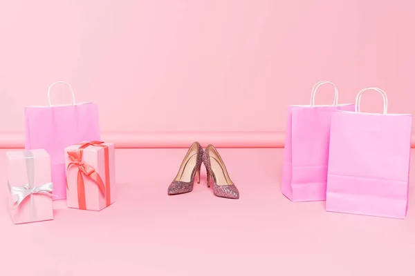Saltos perto de sacos de compras e caixas de presente em rosa — Fotografia de Stock