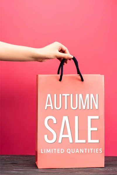 Vista recortada de la mujer sosteniendo bolsa de compras con letras de venta de otoño en rosa, concepto de viernes negro - foto de stock