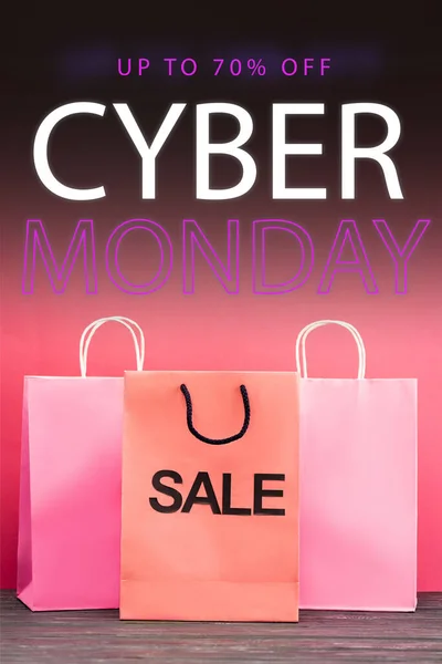 Shopping bag with sale near paper bags near up to 70 percent off, cyber monday lettering on pink, black friday concept — Stock Photo