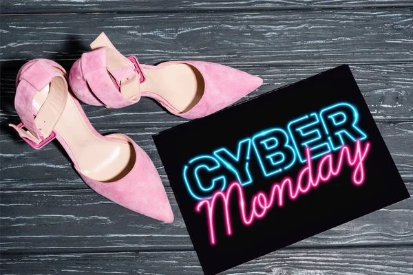 Ansicht von rosa Schuhen in der Nähe von Plakaten mit neonfarbenem Cyber-Monday-Schriftzug auf hölzerner Oberfläche — Stockfoto