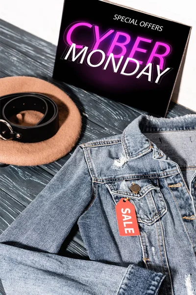 Blue denim jacket near placard with special offers, cyber monday lettering, beret and belt — Stock Photo