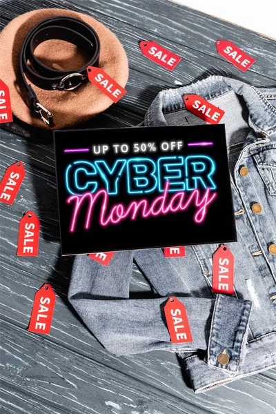 Giacca di denim blu vicino al basco, cintura e cartello con fino al 50% di sconto, lettering cyber lunedì su superficie di legno — Foto stock