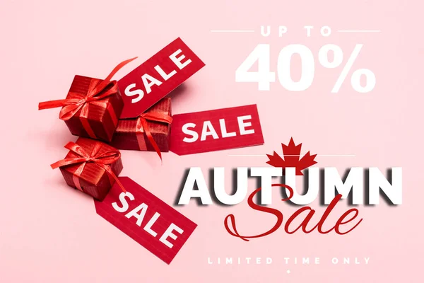 Vista superior de rótulos vermelhos e presentes perto de até 40 por cento de desconto, venda de outono lettering em rosa — Fotografia de Stock