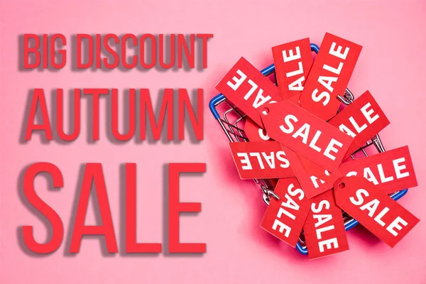 Top view of sale tags in shopping basket near big discount autumn sale lettering on pink, black friday concept — Stock Photo