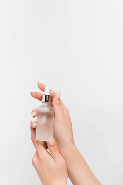 Vue recadrée de la femme tenant bouteille avec sérum isolé sur blanc — Photo de stock