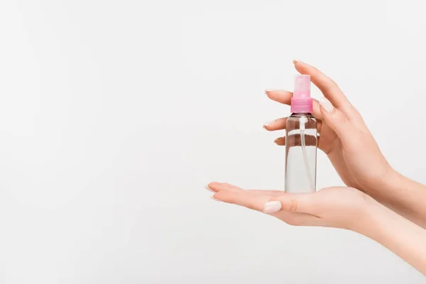 Vue recadrée de la femme tenant le flacon pulvérisateur avec brouillard aromatique dans les mains isolées sur blanc — Photo de stock