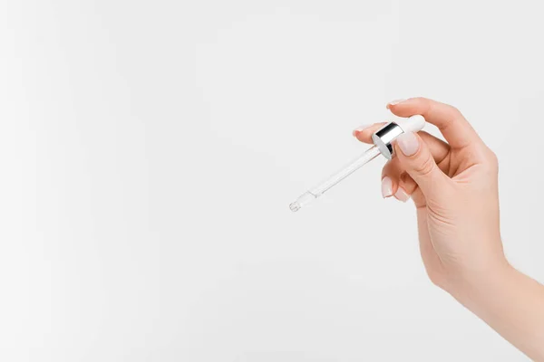 Vista recortada de la mujer sosteniendo la pipeta con suero en la mano aislado en blanco - foto de stock