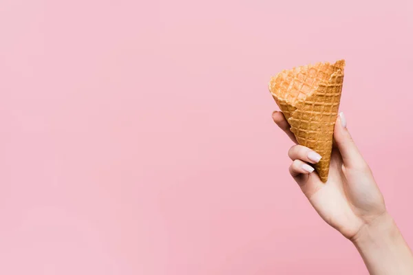 Vue recadrée de femme tenant un cône de gaufre isolé sur rose — Photo de stock
