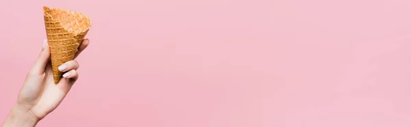 Vista cortada de mulher segurando cone de waffle isolado em rosa, banner — Fotografia de Stock