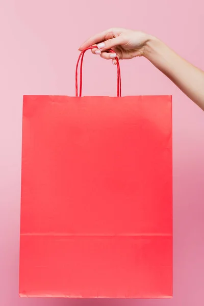Vista cortada de mulher segurando saco de compras isolado em rosa — Fotografia de Stock