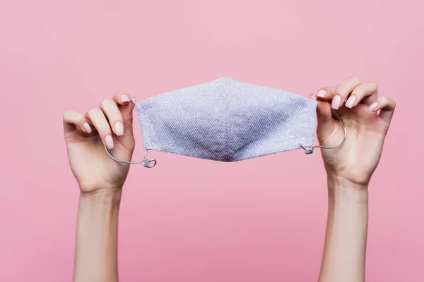 Cropped view of woman holding protective cotton mask in hands isolated on pink — Stock Photo