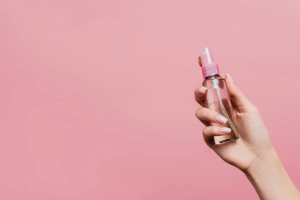 Vista cortada de mulher segurando spray de perfume na mão isolado em rosa — Fotografia de Stock