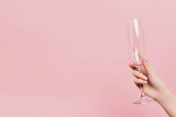 Vue recadrée d'une femme tenant un verre de champagne vide isolé sur rose — Photo de stock