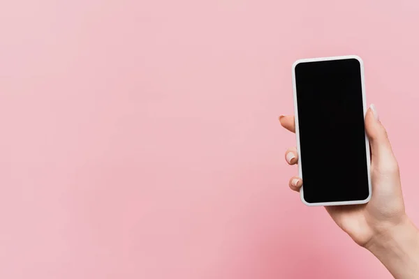 Vista cortada de mulher segurando smartphone com tela em branco na mão isolado em rosa — Fotografia de Stock