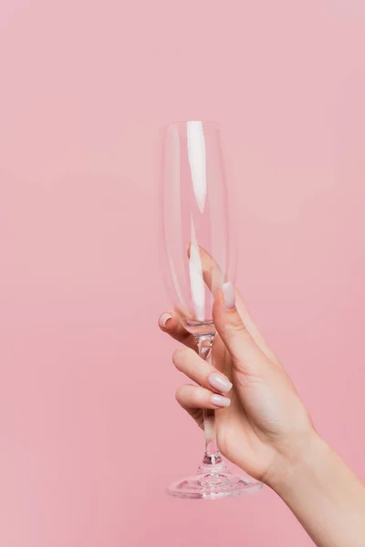 Partial view of woman holding empty champagne glass isolated on pink — Stock Photo