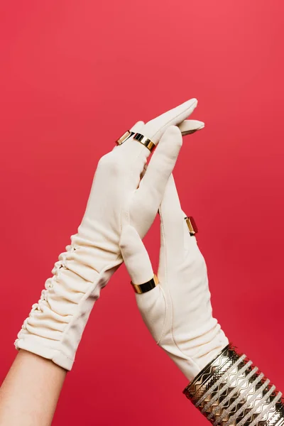 Vista recortada de mujer en guantes con anillos y pulsera aislada en rojo - foto de stock