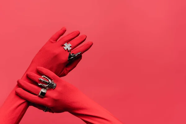 Cropped view of female hands in gloves with rings isolated on red — Stock Photo