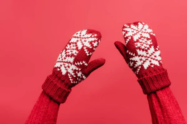 Cropped view of female hands in warm mittens isolated on red — Stock Photo